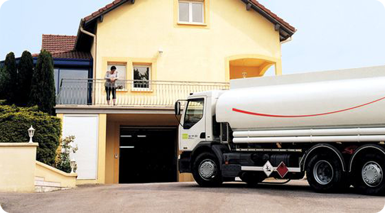 Camion de livraison de fioul domestique devant une maison