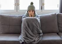 dame avec un plaid qui a froid sur son canapé