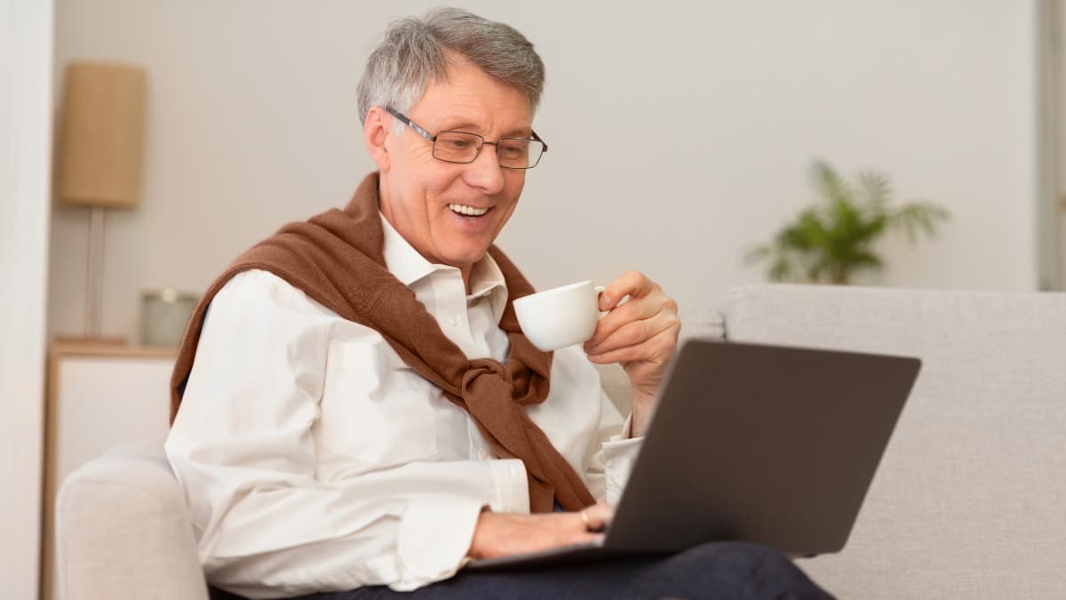 homme sur son ordinateur buvant un café