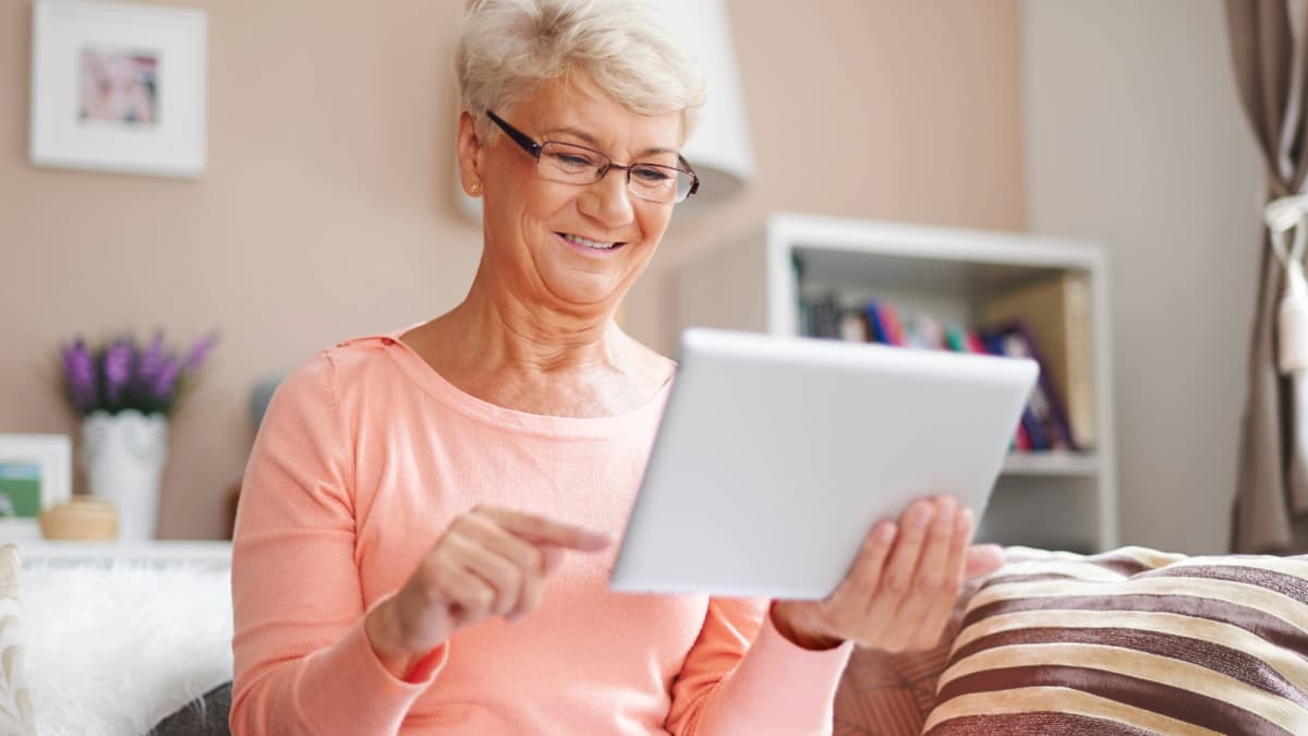 dame souriante qui consulte sa tablette