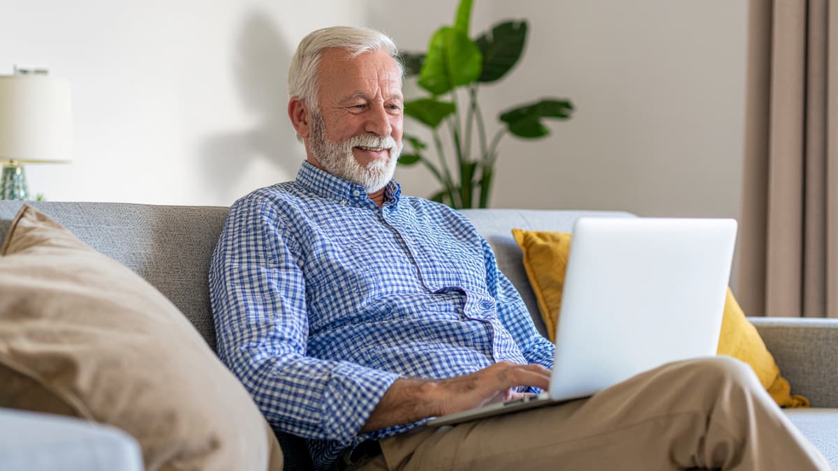 homme consultant son ordinateur sur son canapé